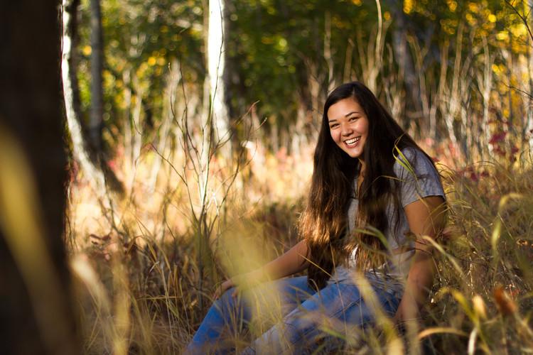 Alyssa casually sitting in the grass. 