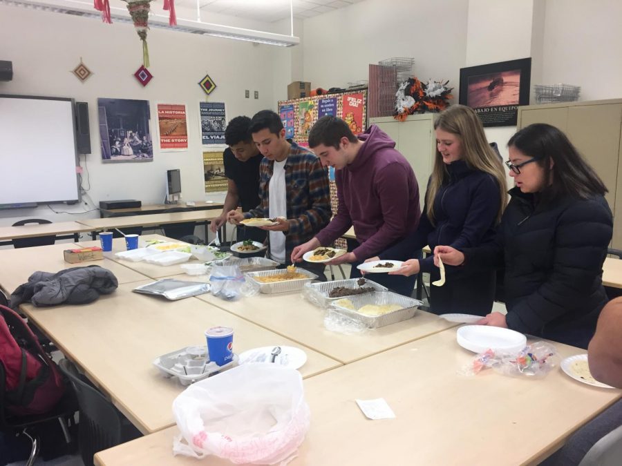 West students eating lunch at a potluck in a classroom.