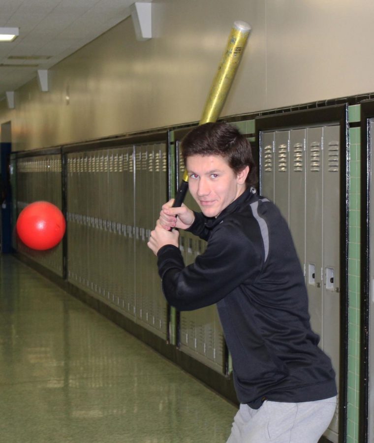 Jack Opinsky batting in the West Anchorage High hallway during class to show some of his summer activities.