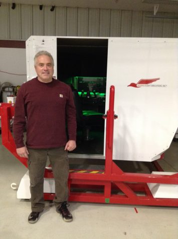 Al Merrill with his RedBird Flight Simulator that is used to teach and train rising pilots.