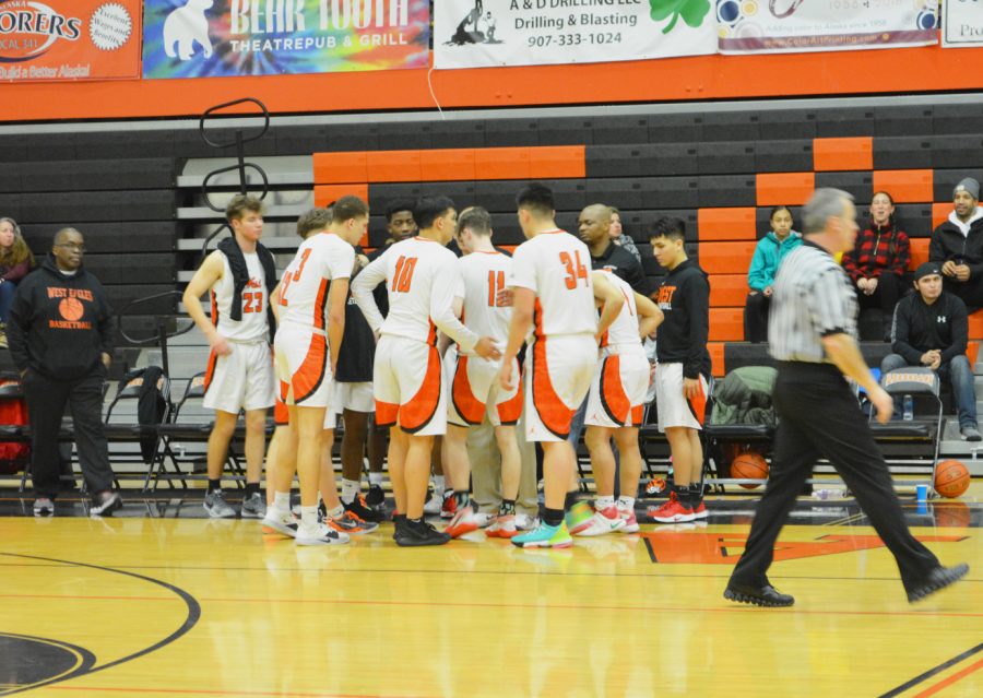 The Eagles team up and huddle together around Coach Muehlenkamp on a West timeout at West Anchorage High School on Tuesday January 21st, 2020.
