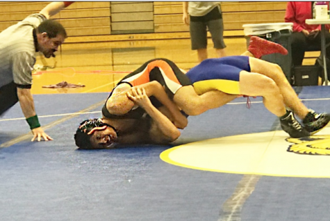 Robert Misa goes for the pin on Gaige Moore at Bartlett High School.